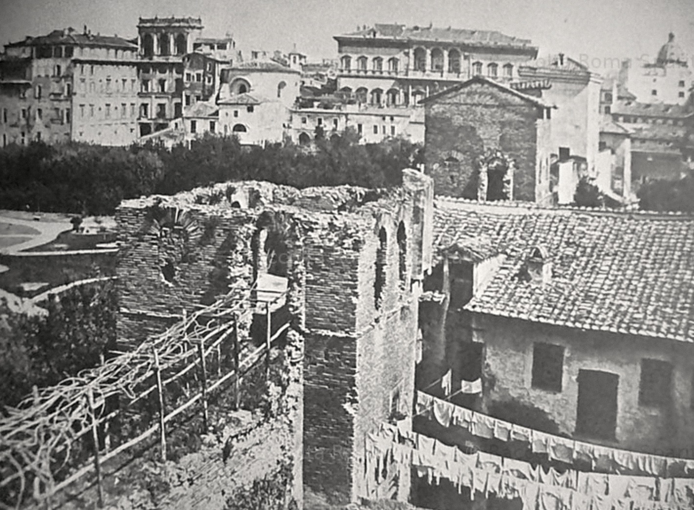 Photograph of Vicolo Moroni in the early 1900s, with laundry hanging across the street and the Aurelian Walls behind